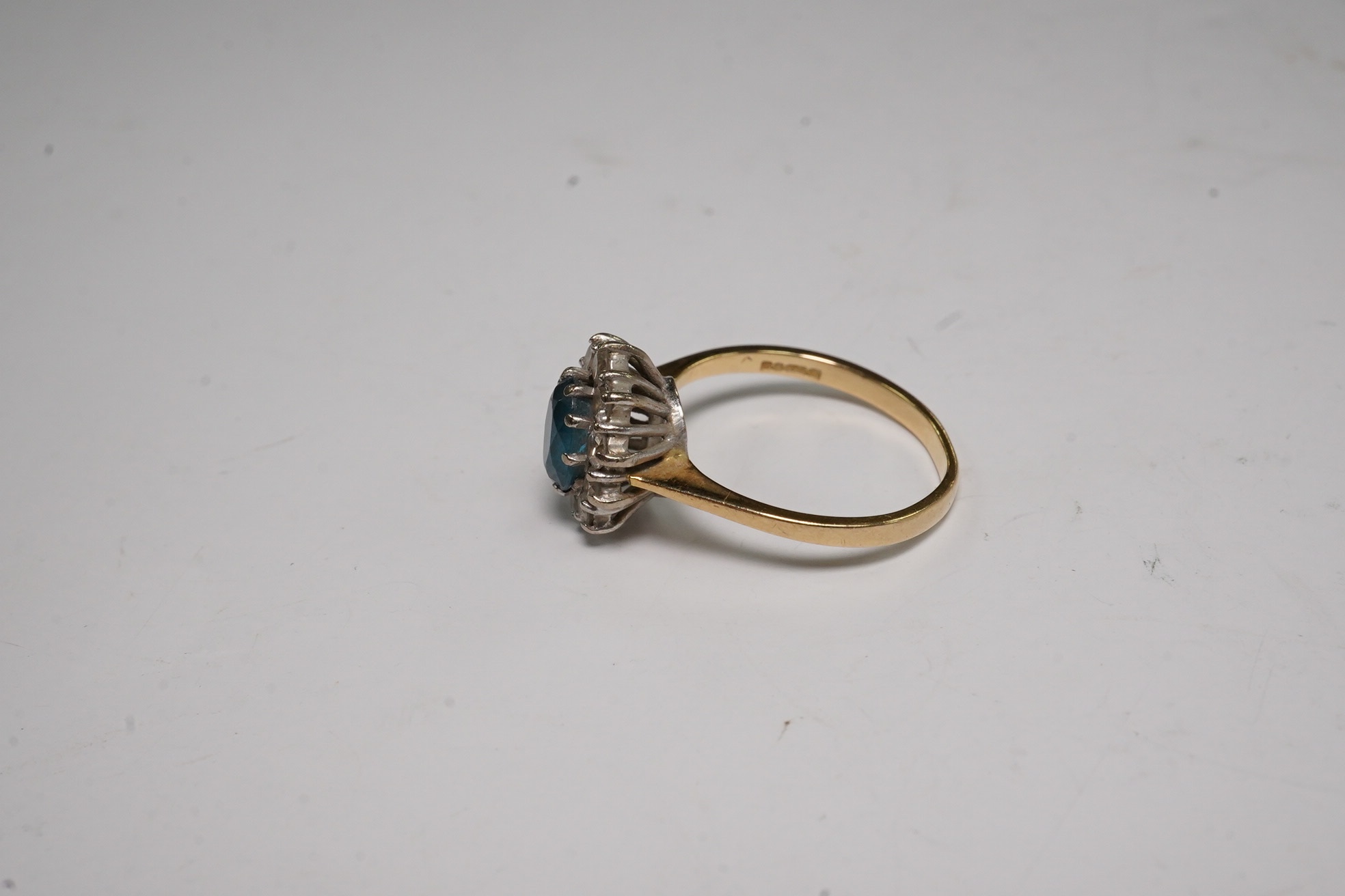 A modern 18ct gold, blue topaz and diamond set oval cluster ring, size M, gross weight 3.5 grams. Condition - fair